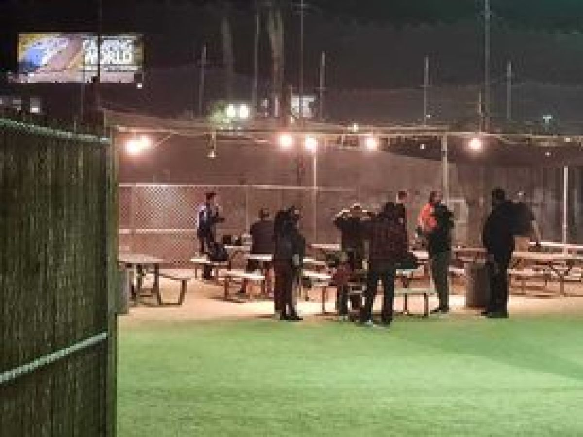 a group of people standing next to a fence