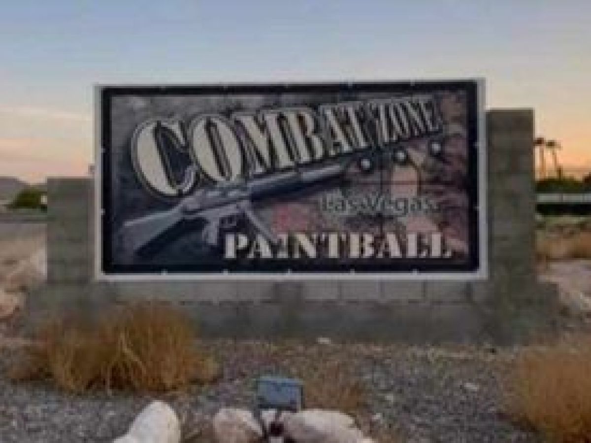 a sign on the side of a dirt field