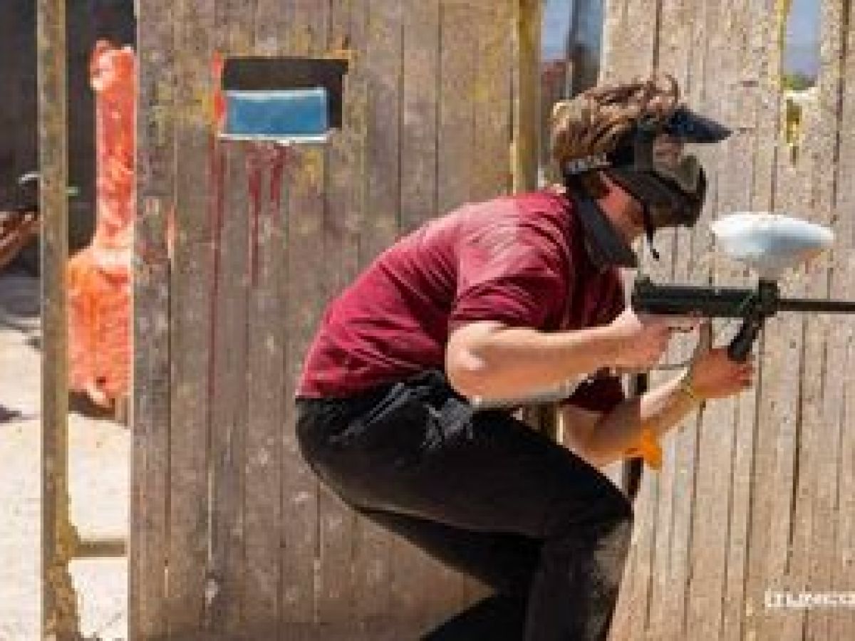 a man standing on top of a wooden fence