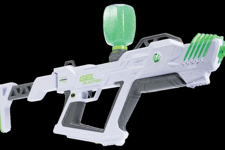 White and green toy gel blaster gun with hopper on top against black background.